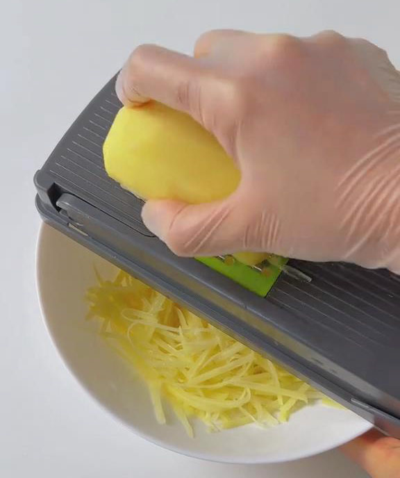 use a grater to shred potatoes and carrot into fine strips